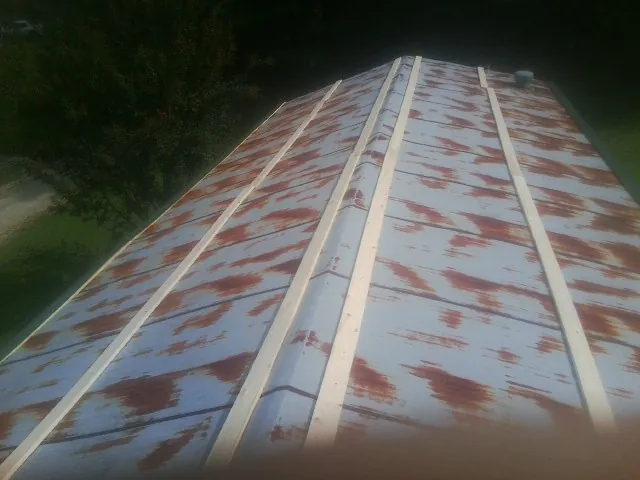 Rusted metal roof panels with new wood purlins before replacement — Storm Damage Roof Repair in Sharps by Roofing Brothers