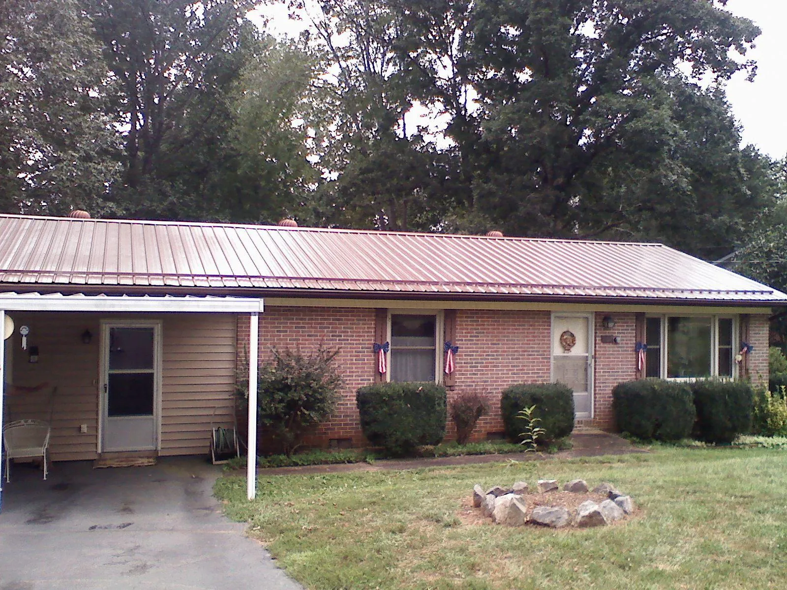 Bronze metal roof and carport on a brick ranch home — Roof Repair work by our crew in Sharps